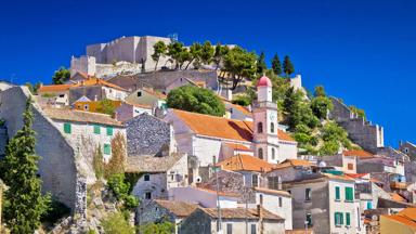 kroatie_dalmatie_sibenik_oude-stenen-stad_berg_bomen_blauwe-lucht_shutterstock