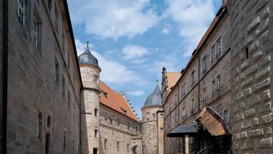 Sie sehen die Festung Rosenberg in Kronach mit Wolken im Sommer. JUFA Hotels bietet kinderfreundlichen und erlebnisreichen Urlaub für die ganze Familie.