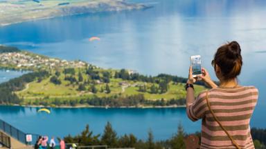 nieuw-zeeland_zuidereiland_queenstown_uitzicht_reiziger_vrouw_single_fotograferen_telefoon_b