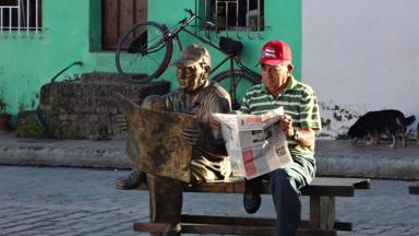 cuba_camaguey_man leest krant naast gelijksoortig standbeeld_w(1).jpg