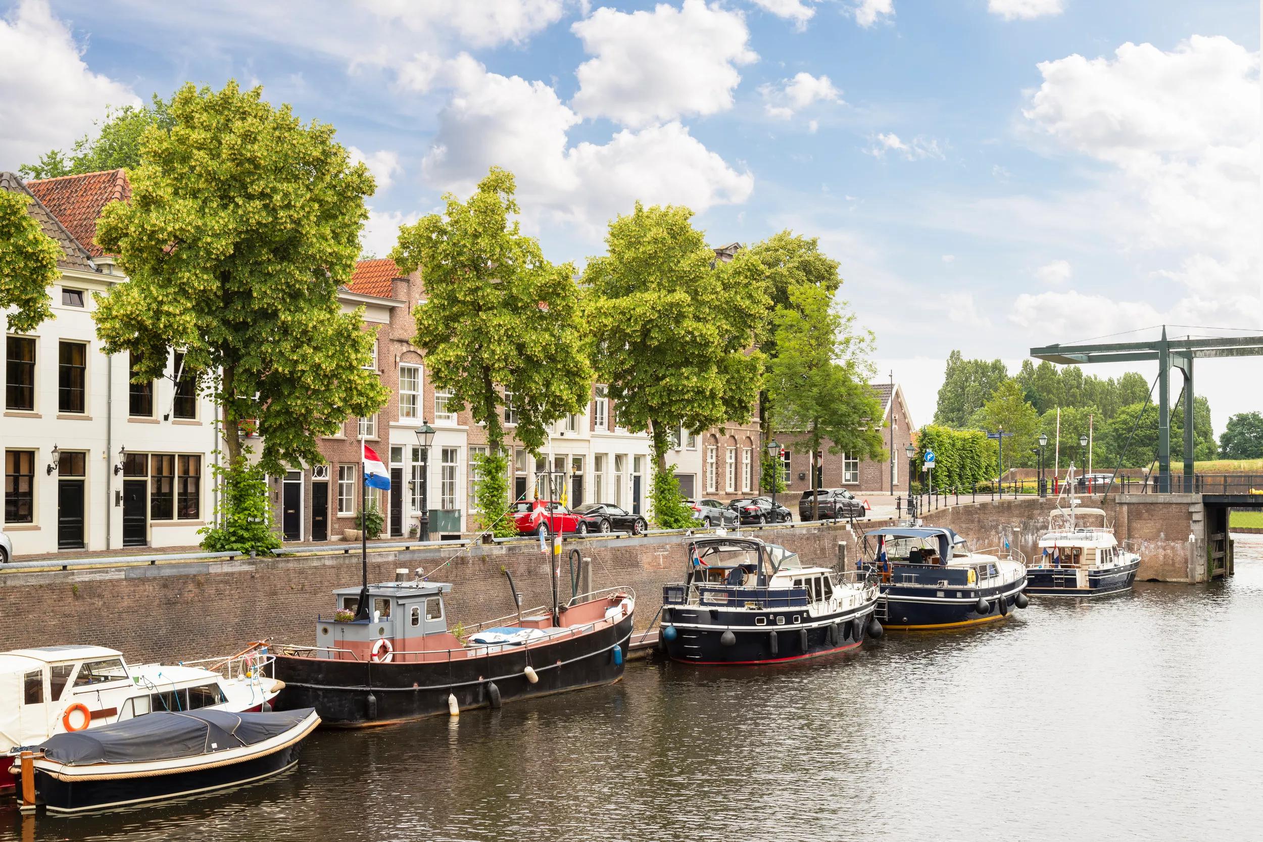 The old harbor in Den Bosch, with boats and medieval houses in the Netherlands.