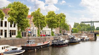 The old harbor in Den Bosch, with boats and medieval houses in the Netherlands.