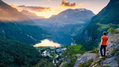 noorwegen_more-og-romsdal_geirangerfjord_man_uitzicht_fjord_dal_bergen_zonsondergang_GettyImages-1168909313