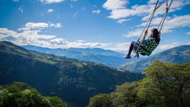ecuador_banos_banos-de-agua-santa_casa-del-arbol_schommel_vrouw_uitzicht_wolk_shutterstock