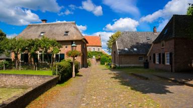 A street with medieval houses under a nicely clouded sky in the small village of Bronkhorst, The Netherlands