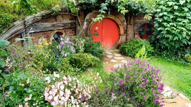 nieuw-zeeland_noordereiland_matamata_hobbiton-movie-set_rode-deur_bloemen