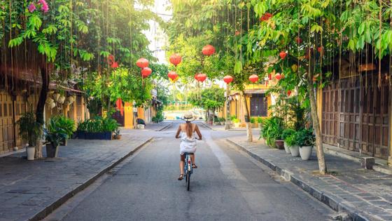 Women visiting the old city of Hoi An in Vietnam by bike during morning