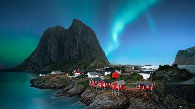 Noorwegen-Lofoten-berg-rode huizen-noorderlicht-Getty