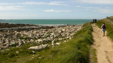 frankrijk_bretagne_ile-grande_wandelen_vrouw_wandelpad_rotsen_zee_GettyImages-700735647