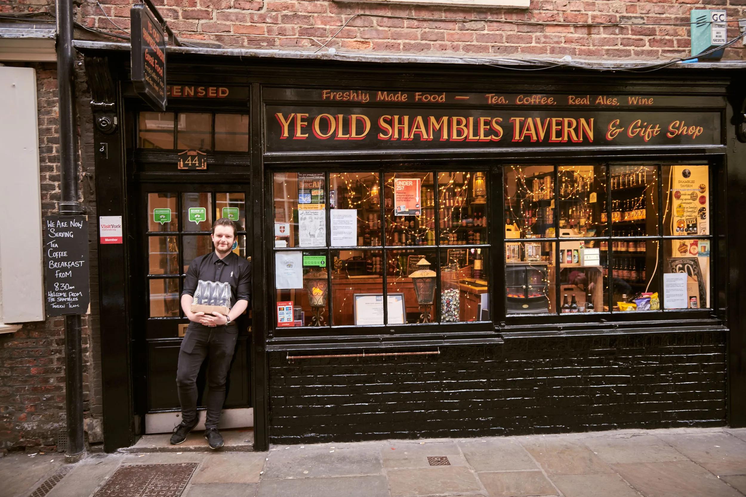 Man standing outside Ye Old Shambles Tavern in York, North Yorkshire, England.
