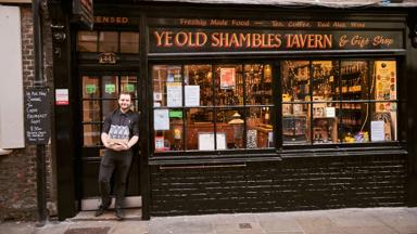 Man standing outside Ye Old Shambles Tavern in York, North Yorkshire, England.