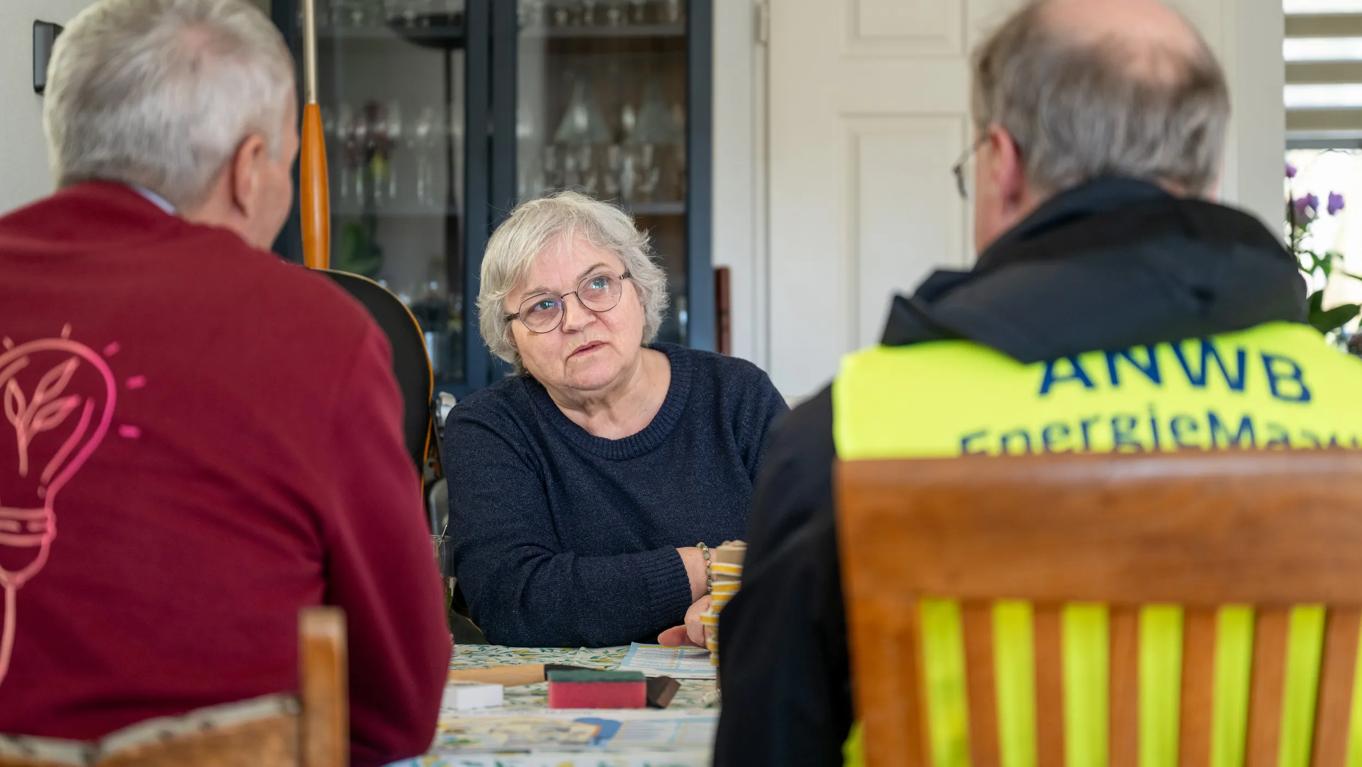 Vrijwilligers voor ANWB EnergieMaatje die energieadvies geven aan een bewoonster
