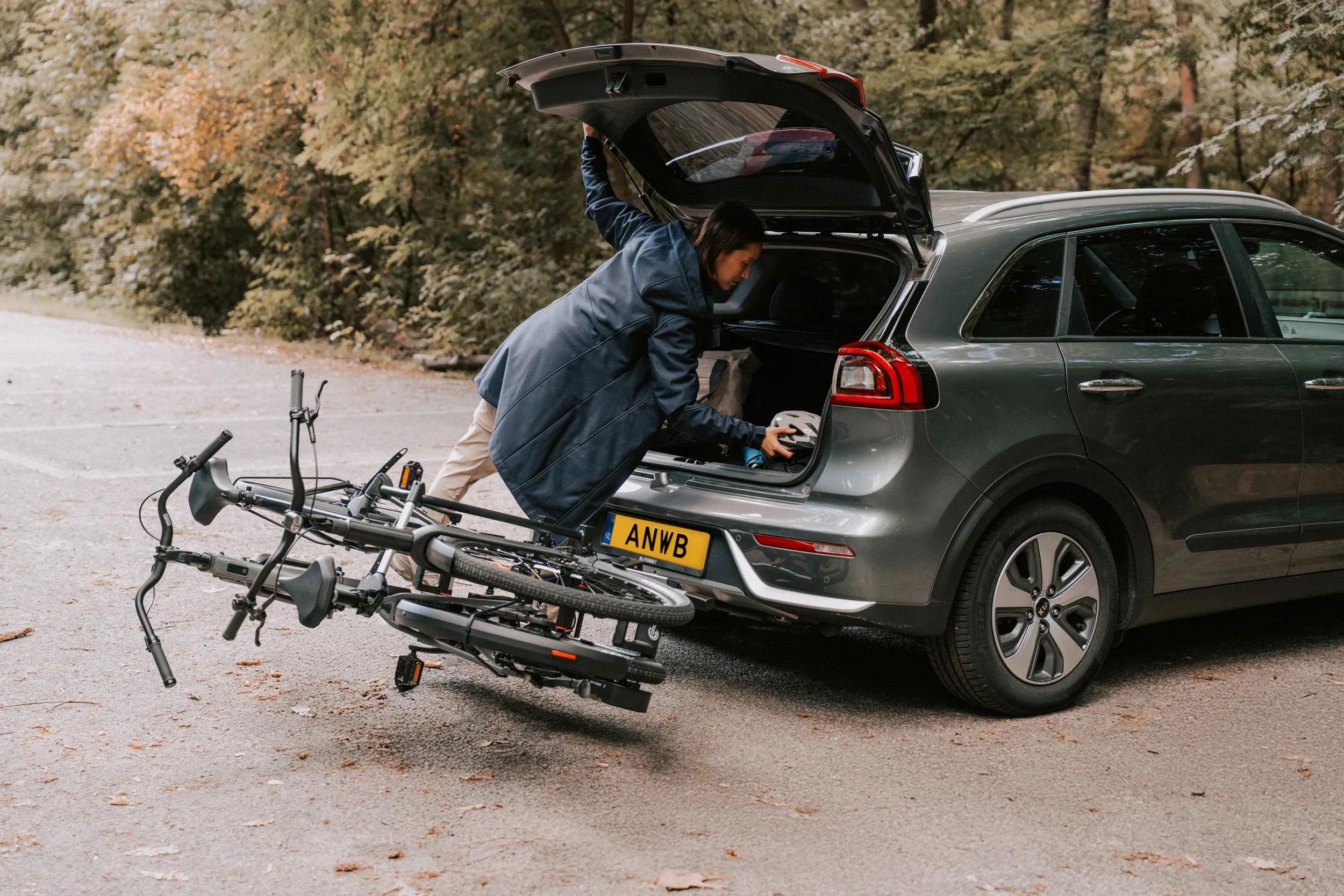 Vrouw bij auto met fietsendrager