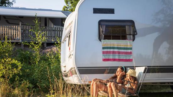 Stel geniet in zon voor caravan