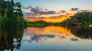 suriname_amazone-regenwoud_algemeen_groepsreis-suriname_amazone-regenwoud_amazone-rivier_reflectie-zonsondergang_shutterstock