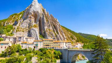 frankrijk_hautes-alpes-cote-d-azur_sisteron_berg_rots_brug_rivier_huizen_shutterstock_1492897376