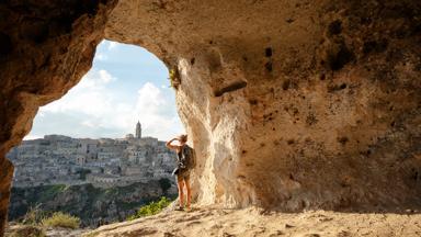 italie_puglia_matera_grot_vrouw_toerist_uitzicht_stad_berg_getty