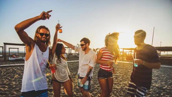 Feestende jongeren op het strand