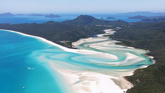 australie_queensland_whitsundays_whitehaven-beach_overzicht_bootjes_strand_gebergte_eilanden