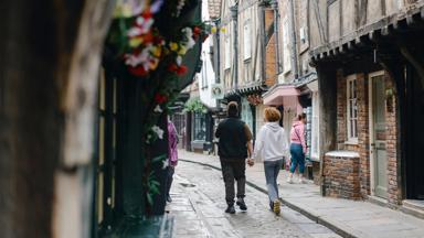 A man and woman holding hands on the Shambles, York