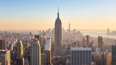 verenigde-staten_new-york-city_manhattan_empire-state-building_skyline_rivier_wolkenkrabbers_blauwe-lucht_shutterstock