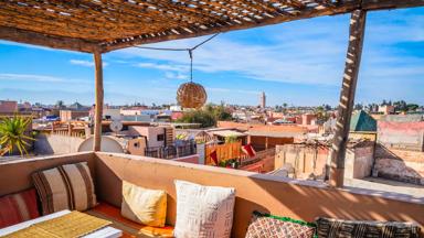 marokko_marrakech_dakterras_overzicht-stad_toren_kussens_daken