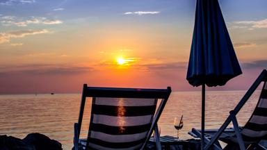 kroatie_istrie_umag_strandstoel_zonsondergang_zee_glas_parasol_getty