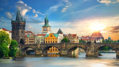 tsjechie_praag_karelsbrug_mensen_rivier-moldau_zonsondergang_boot_getty