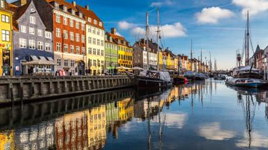 Nyhavn is a 17th-century waterfront, canal and entertainment district in Copenhagen, Denmark. Stretching from Kongens Nytorv to the harbour front just south of the Royal Playhouse, it is lined by brightly coloured 17th and early 18th century townhouses and bars, cafes and restaurants. Serving as a "heritage harbour", the canal has many historical wooden ships.