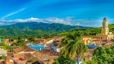 cuba_trinidad_overzicht-stad_sierra-escambray_kerk_gekleurde_huizen_daken_groen-gebergte_panorama.jpg