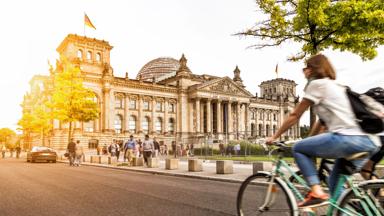 duitsland_berlijn_berlijn_fietsvakantie-duitsland_vrouw_reichstag_fietsen-zon_shutterstock