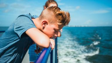 algemeen_ferry_veerboot_kind_jongen_meisje_reling_zee_GettyImages-1208591237