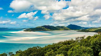 australie_queensland_airlie-beach_blauwe-zee_bomen_witte-strand_bergen_shutterstock