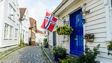 noorwegen_rogaland_stavanger_gamle-stavanger_vlag_straatje_huizen_deur_kinderkopjes_GettyImages-596787641