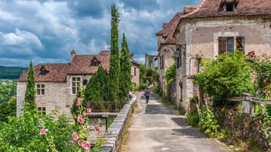 frankrijk_occitanie_saint-cirque-lapopie_straat_boom_wolkenlucht_getty