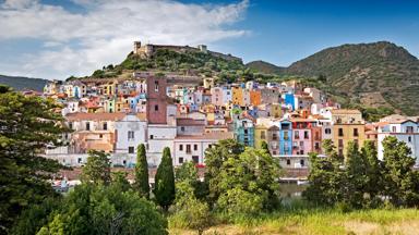 italie_sardinie_bosa_kleurrijke-huizen_heuvel_kasteel_GettyImages-825839116