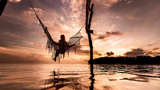 indonesie_bali_vrouw_hangmat_zonsondergang_GettyImages-1210051469