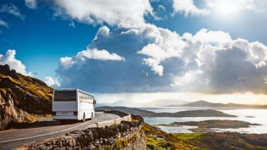 Tourist bus traveling on mountain road. Ring of Kerry, Ireland. Travel destination