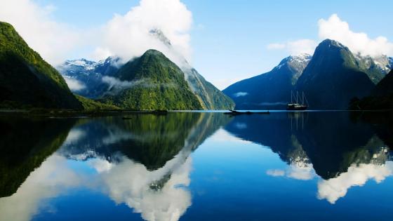 nieuw-zeeland_zuidereiland_fiordland-national-park_milford-sound_boot_water_fjorden_gebergte_besneeuwde-bergtop_weerspiegeling