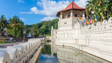 sri-lanka_kandy_tempel-van-de-tand_tempel-mensen-vijver_palmbomen_boeddhistische-vlaggetjes_shutterstock