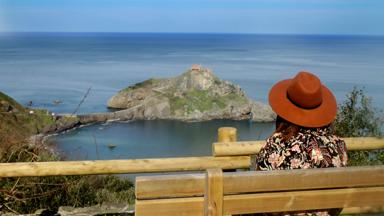 Tourist admiring the view in San Juan de Gaztelugatxe, Bilbao, Spain