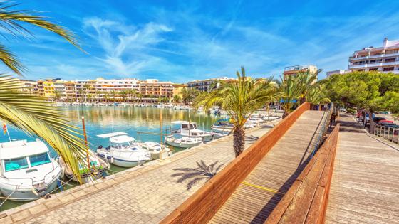 spanje_mallorca_puerto-de-alcudia_haven_steiger_kade_palmboom_boot_zee_flat_hotel_getty