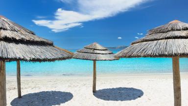 frankrijk_corsica_porto-vecchio_palombaggia_strand_parasol_azuurblauw_zee_schaduw_zandstrand_getty