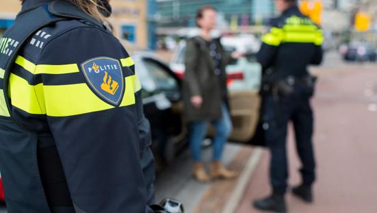 Politieagent in gesprek met automobilist.