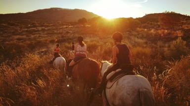 portugal_algarve_paardrijden_gezin_vrouw_meisje_paard_zonsondergang_heuvels_GettyImages-769835967