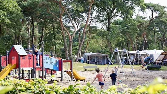 Speeltuin met spelende kinderen op camping Beerze Bulten.