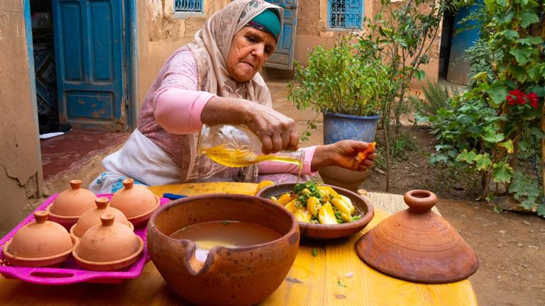 Portrait of Berber old woman in traditional dress preparing tagine lunch, Agounssan, High Atlas, Morocco (Model Release)