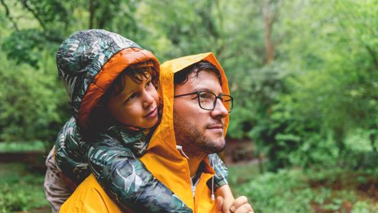 Vader en zoon wandelen in de regen