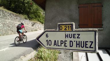 frankrijk_Auvergne-Rhone-Alpes_Huez_Alpe-d-Huez_mountainbike_man_verkeersbord_GettyImages-92314979