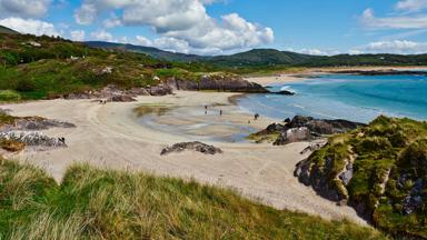 ierland_county-kerry_ring-of-kerry_strand_duingras_zee_mensen_heuvels_getty